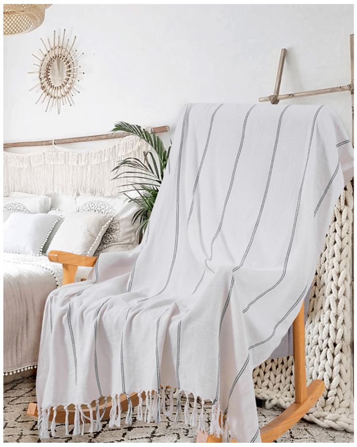 a white blanket sitting on top of a wooden rocking chair