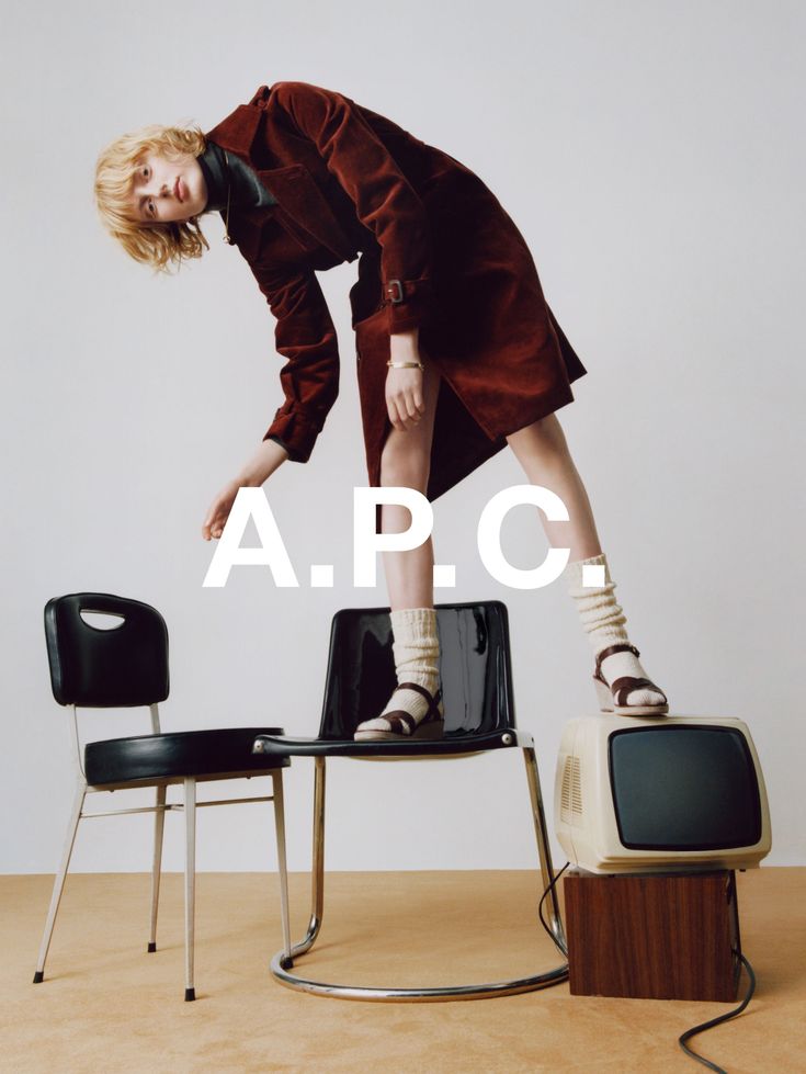 a woman standing on top of a chair in front of a tv with the caption apc