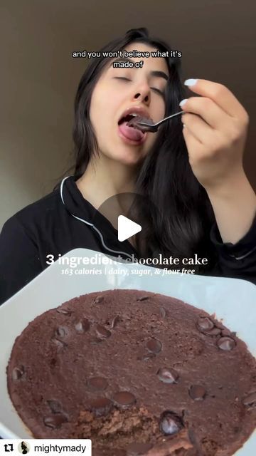 a woman eating chocolate cake from a white plate with a spoon in her mouth and an ad on the screen