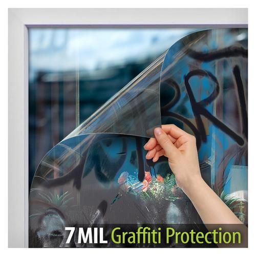 a person holding an umbrella in front of a window with graffiti written on it and the words, 7ml graffiti protection