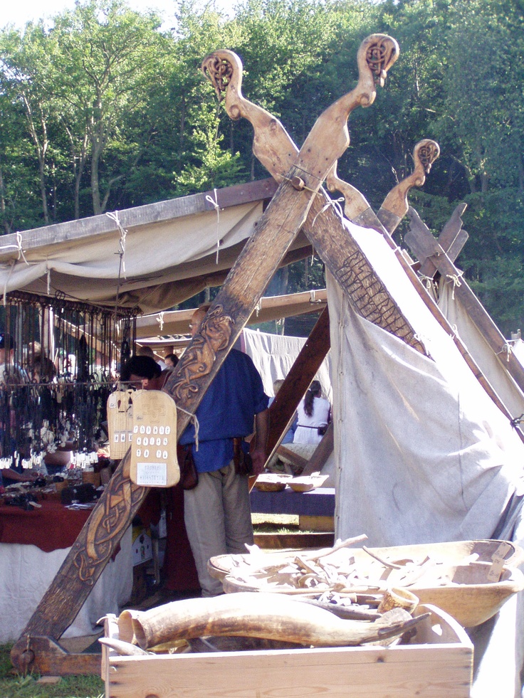 a man standing in front of a tent with an animal sculpture on it's side