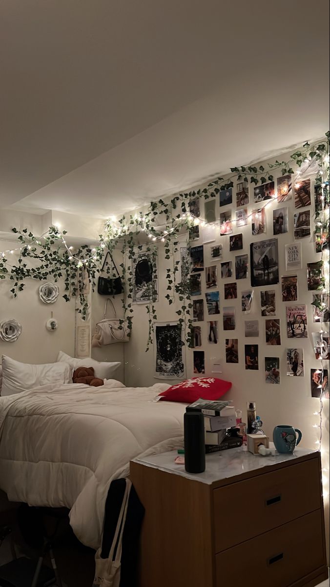 a bed room with a neatly made bed and lots of pictures on the wall above it