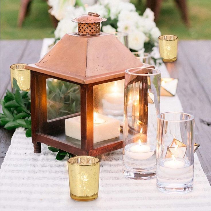 a table topped with candles and vases filled with flowers