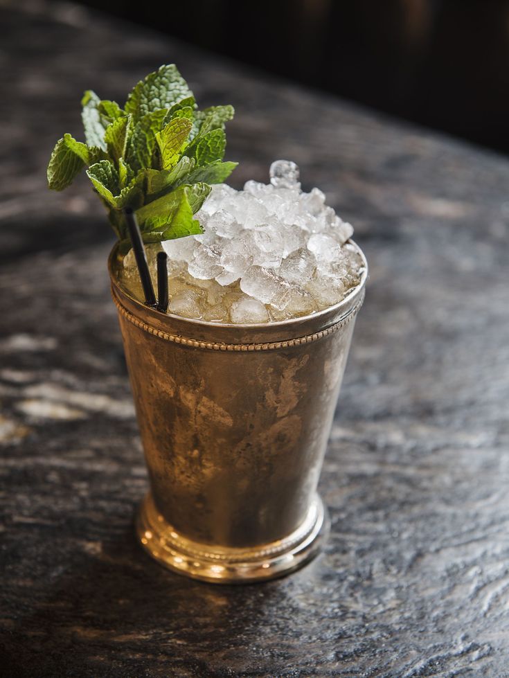 a glass filled with ice and mint on top of a table