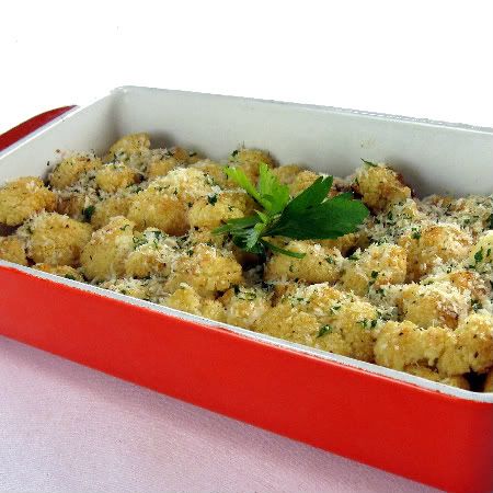 a red casserole dish filled with food and garnished with parsley