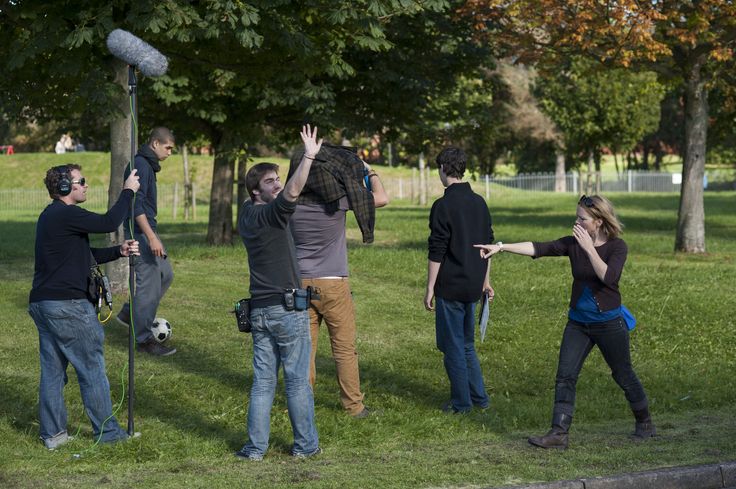 several people standing in the grass with their hands up