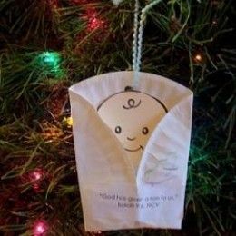 an ornament hanging from a christmas tree in the shape of a baby's head