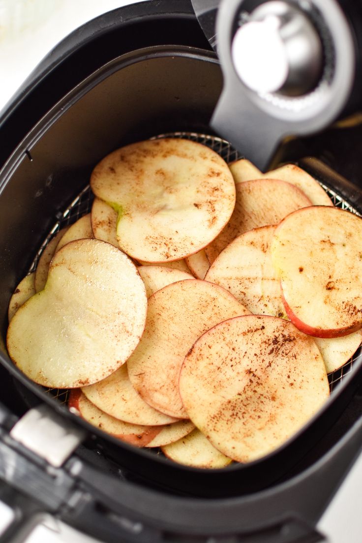 an air fryer filled with sliced apples