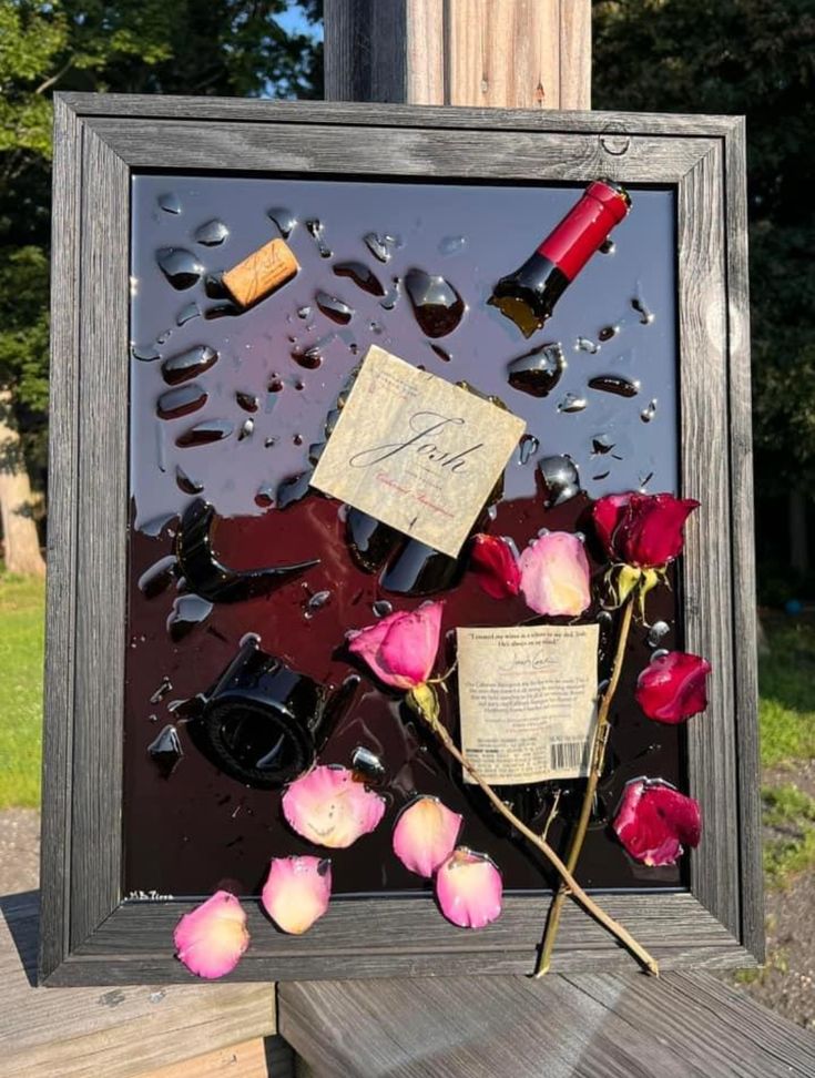 roses and wine bottles are on display in a shadow box with water droplets surrounding them