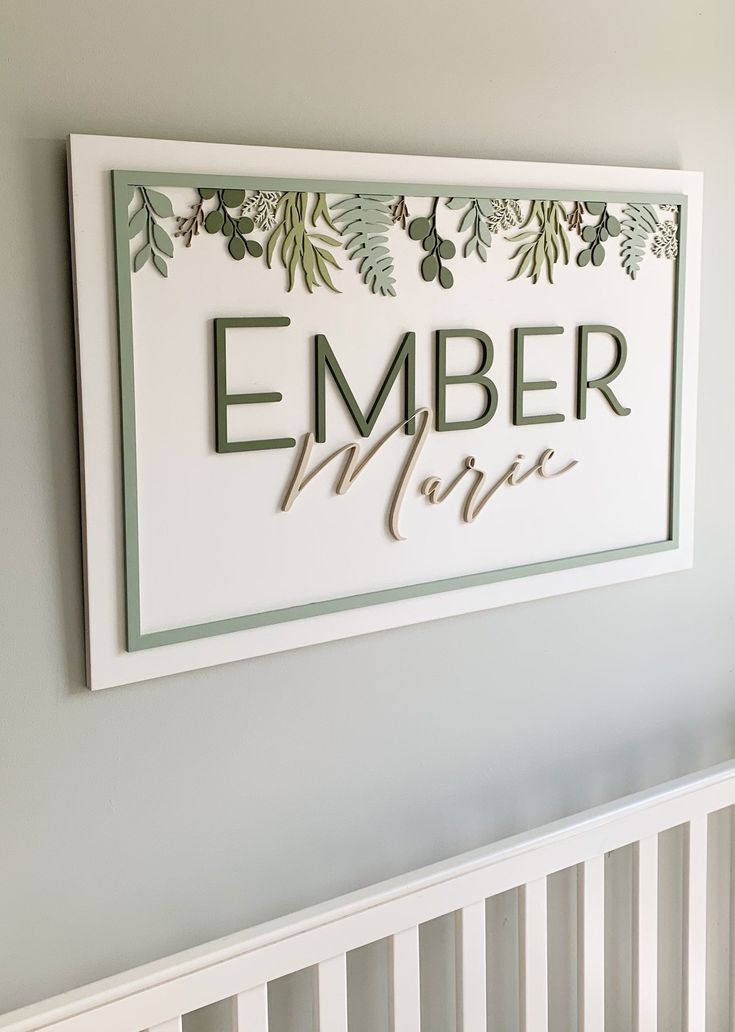 a white crib with a sign that says ember mare next to the crib