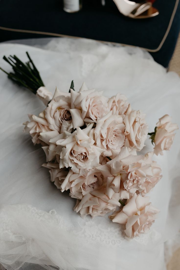 the bridal bouquet is laying on the bride's wedding dress with her shoes in the background