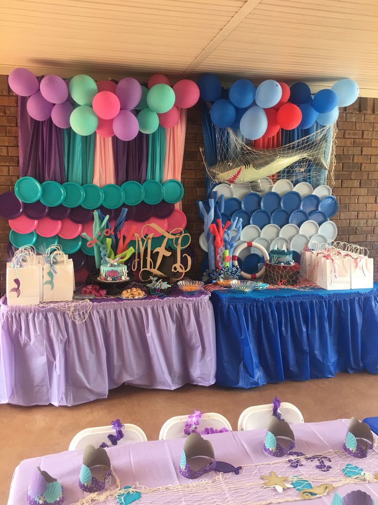 an under the sea themed birthday party with balloons, cake and desserts on tables