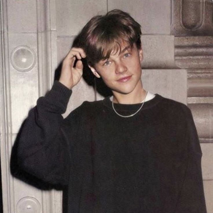 a young man is wearing a black sweater and earphones in front of a door