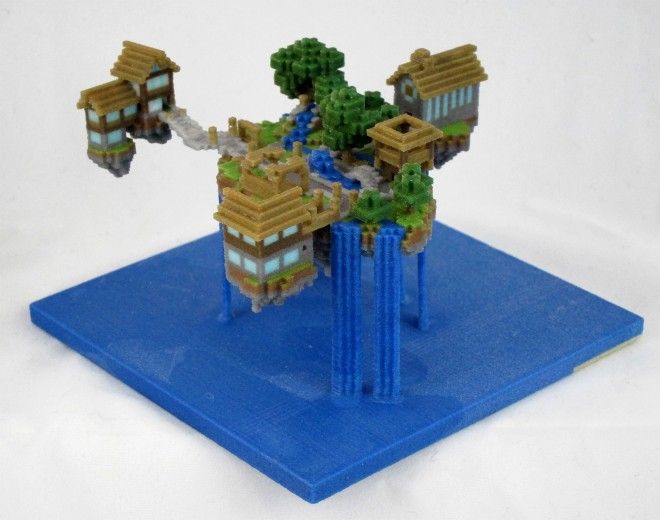 a lego model of a house on top of a blue platform with trees and bushes