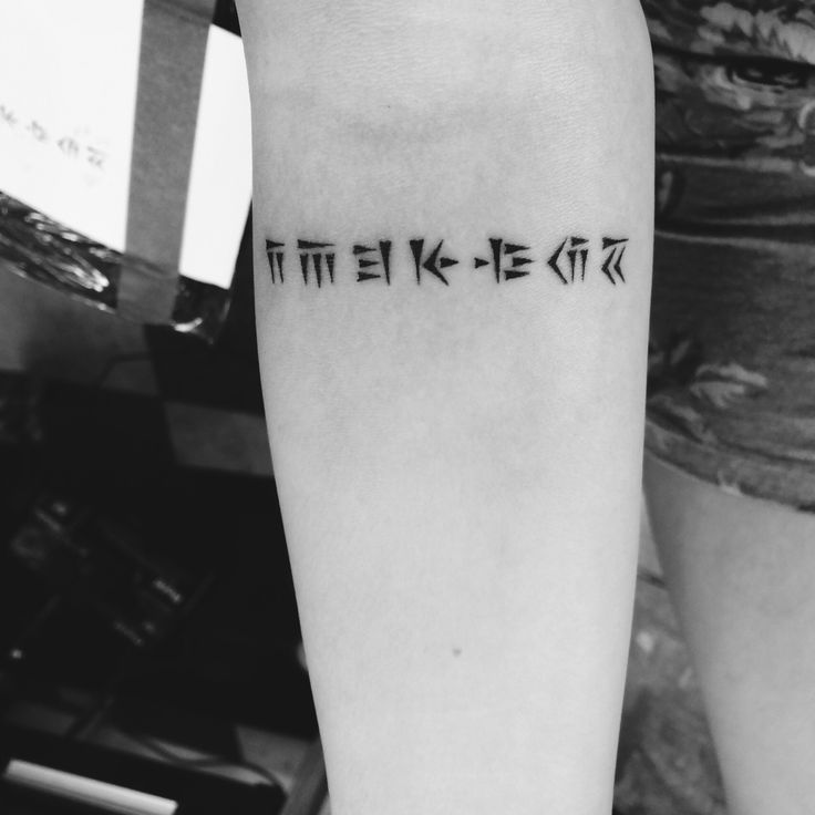 a person with a tattoo on their arm that says it's okay to be in chinese