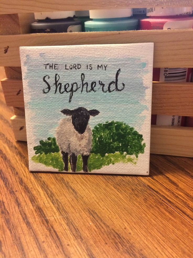 the lord is my shepherd painted on a wood block with some books in the background