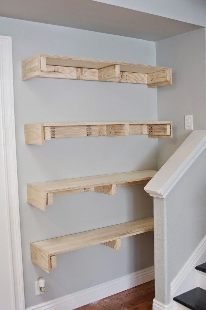 the shelves are made out of wood and have been placed on the wall for storage