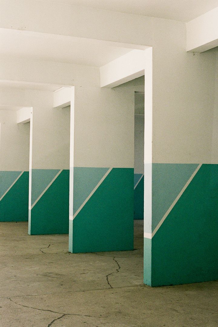 an empty parking garage with green and white walls