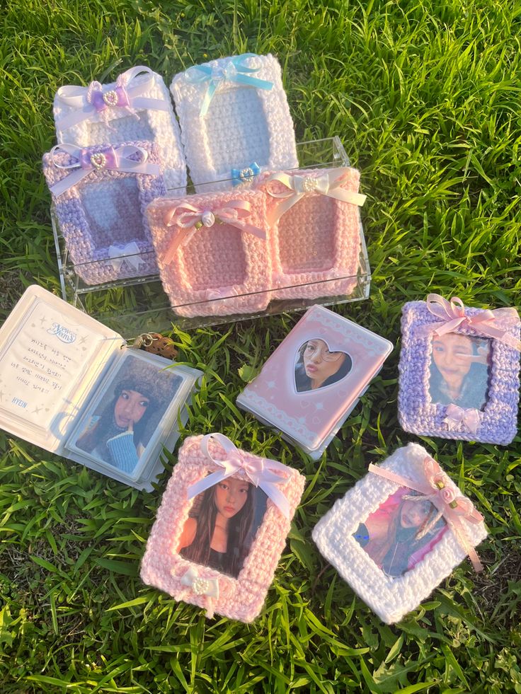 there are many small frames with pictures in them on the grass and one is holding a baby's photo