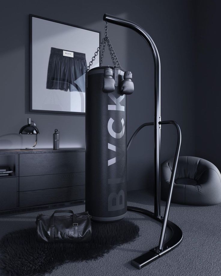 a black and white photo of a punching bag in a gray room with a mirror on the wall