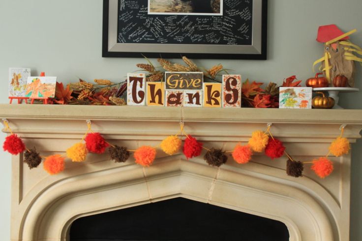 a fireplace mantel decorated with fall decorations and give thanks signs on it's mantle