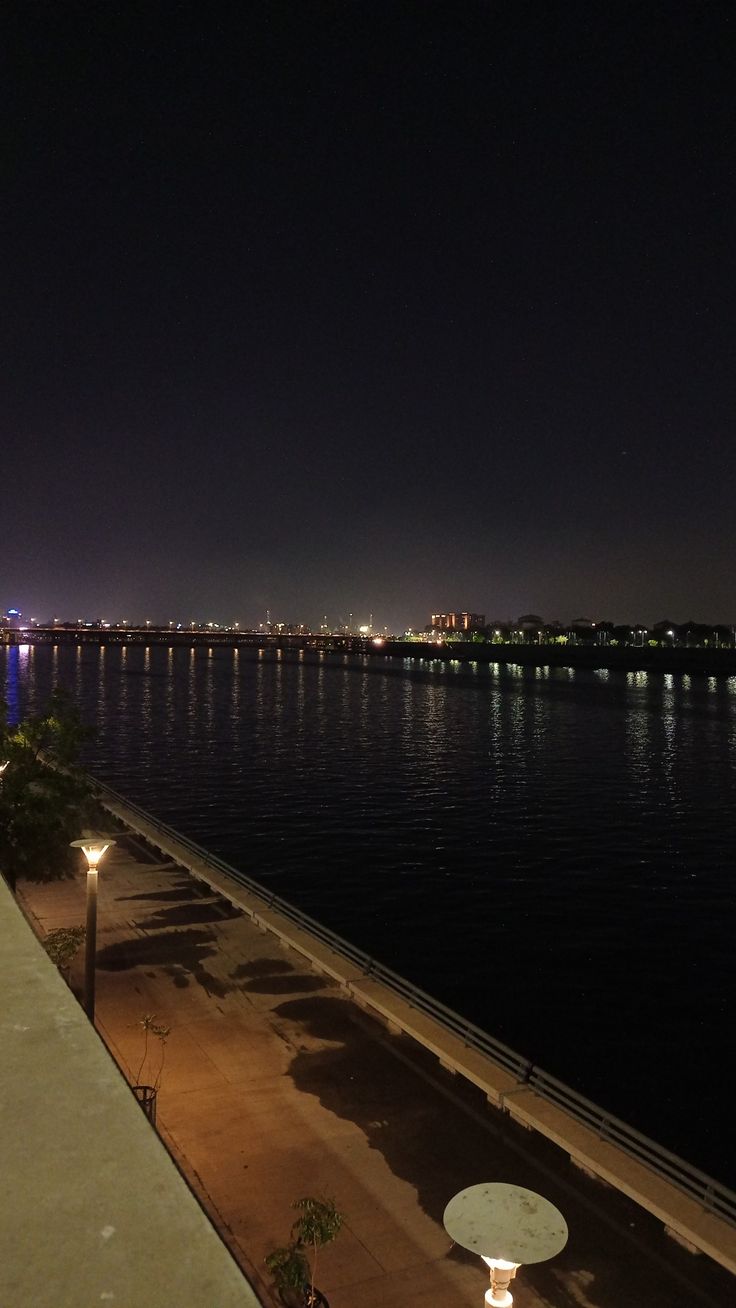 a view of the water at night with lights on