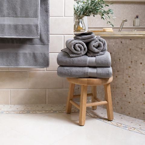 towels are stacked on a stool in the bathroom