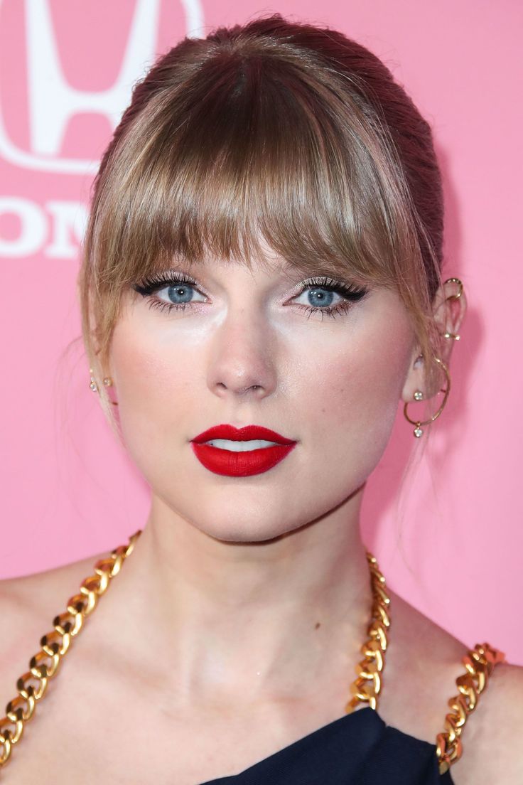 taylor swift wearing red lipstick and gold necklace