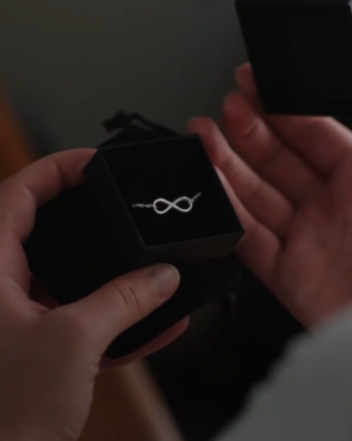 a person holding a box with a ring in it's hand and looking at the camera