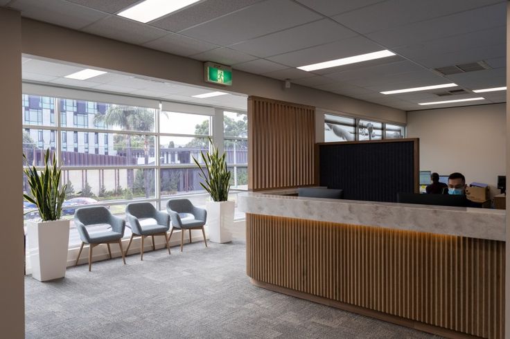 an empty office with chairs and plants in it