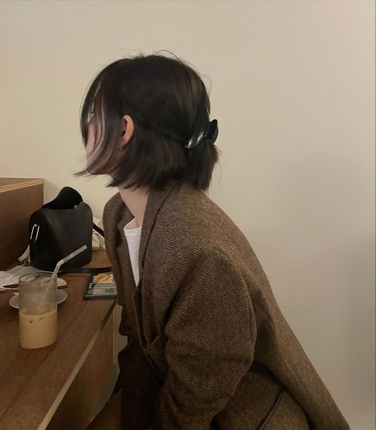 a woman sitting at a desk with a black purse