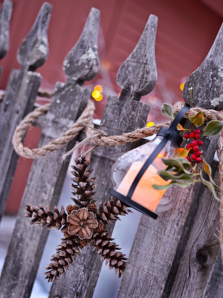 a wooden fence decorated with pine cones and lights