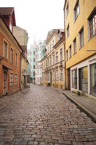 an empty cobblestone street with buildings in the background