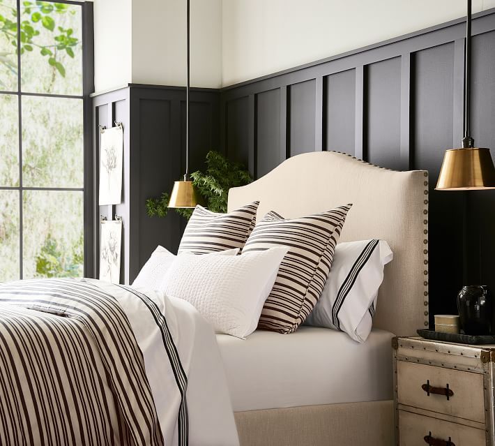 a bed with black and white striped pillows