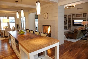 a dining room table with chairs and a clock on the wall