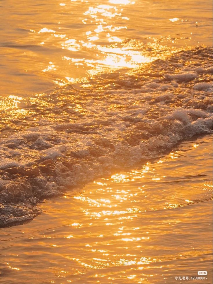 the sun is setting over the water at the beach