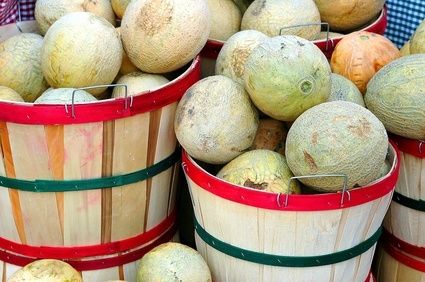 several buckets filled with different types of fruit