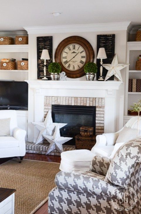 a living room filled with furniture and a large clock on the wall above it's fireplace