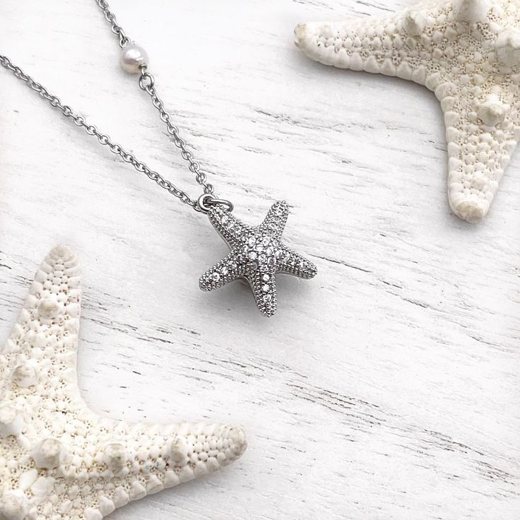 Dive into whimsical elegance with our Starfish Hidden Pearl Necklace—a playful yet refined masterpiece that captures the enchanting splendor of the starfish. This exquisite necklace unveils a hidden pearl within the intricacies of the starfish design, adding a touch of mystery to its charm. Whether worn for a special occasion or to elevate your everyday style, this piece is a testament to seaside allure. Bring the magic of the ocean to your ensemble and showcase your love for marine-inspired sop Elegant Starfish Charm Necklace, Elegant Starfish Charm Star Necklace, Elegant Star-shaped Necklace With Starfish Charm, Elegant Starfish Necklace For Gift, Elegant Jewelry With Starfish Charm, Elegant Star-shaped Jewelry With Starfish Charm, Elegant Starfish Charm Pendant Jewelry, Elegant Pendant With Starfish Charm, Elegant Starfish Charm Necklace For Beach