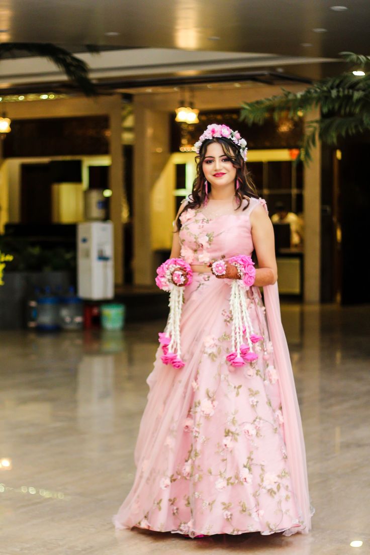 a woman in a pink wedding dress holding flowers