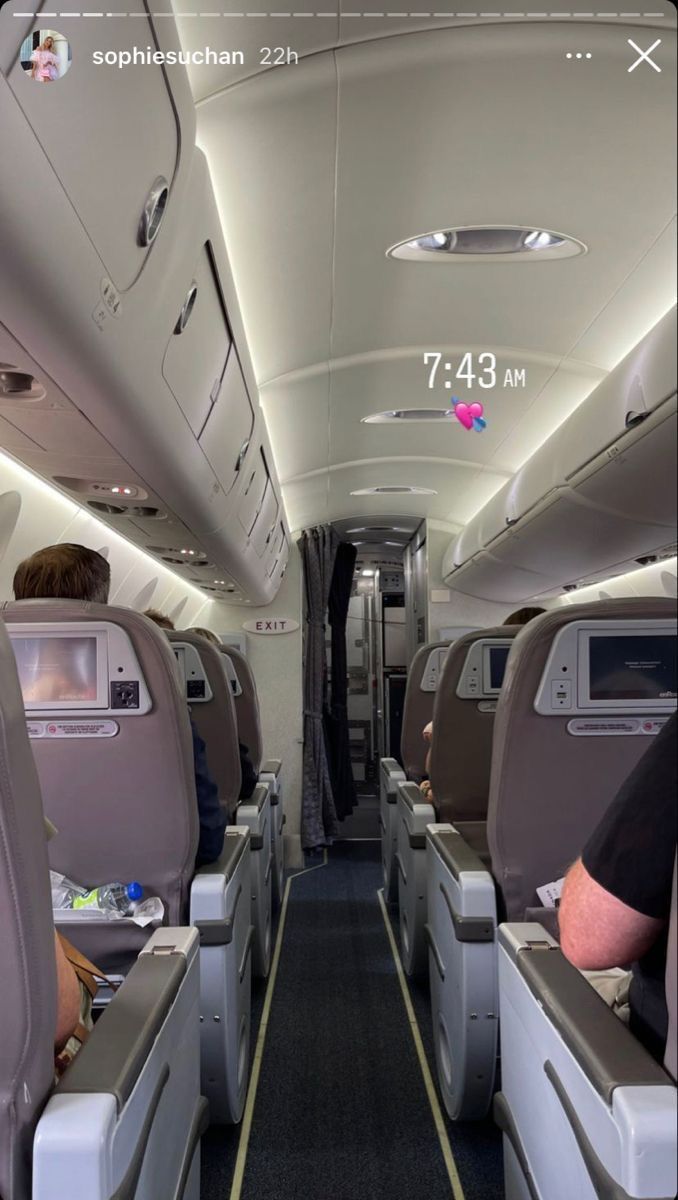 the inside of an airplane with people sitting on seats