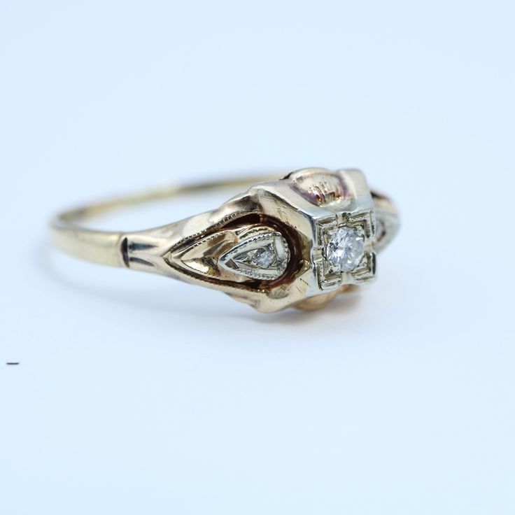 a gold ring with two diamonds on it