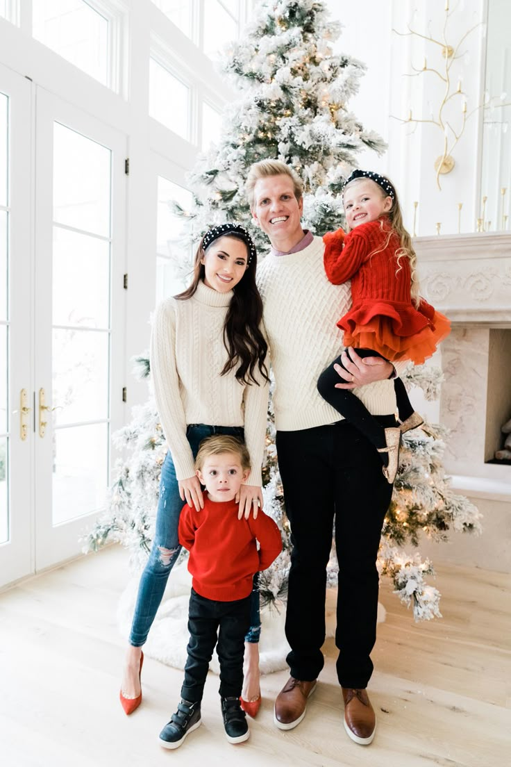 a family standing in front of a christmas tree