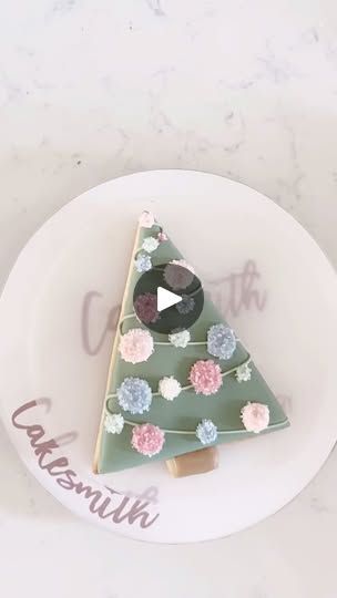 a decorated christmas tree on a plate with the word congratulations written in pink and blue