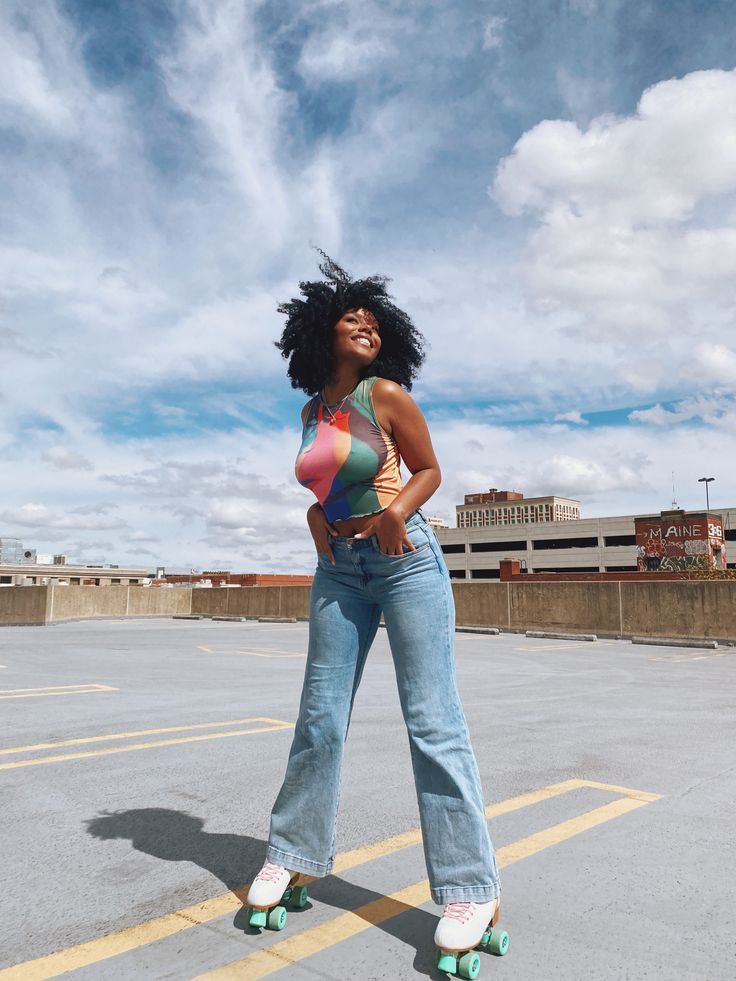 a woman standing in the middle of an empty parking lot with roller skates on her feet