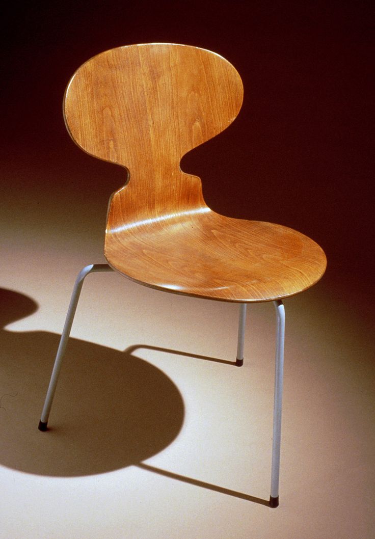 a wooden chair sitting on top of a white floor next to a light brown wall