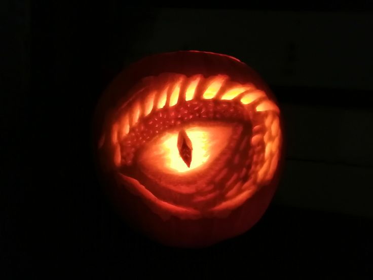 an eye carved into a pumpkin with the light shining on it's side and inside