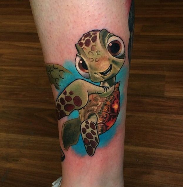 a tattoo with a turtle on it's leg and an image of a fish