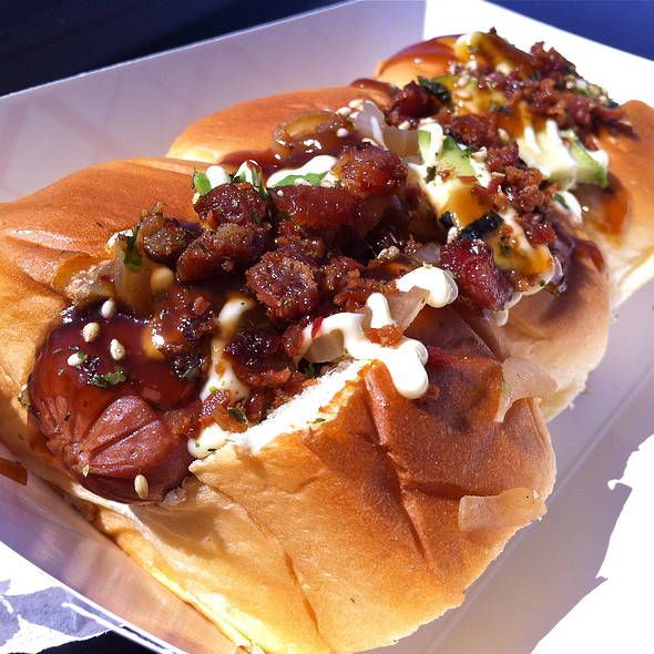 a hot dog in a bun with toppings on it