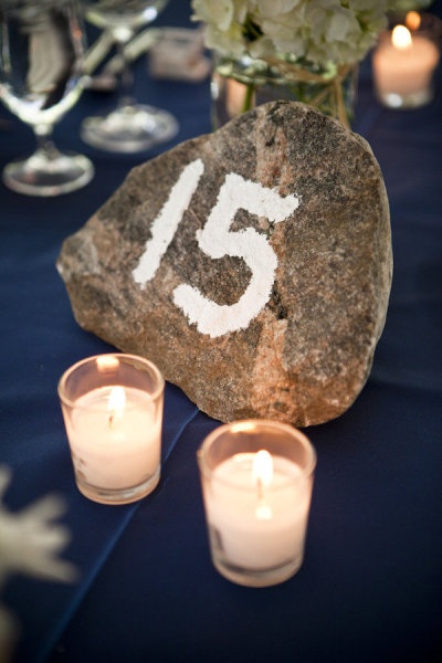 candles are lit next to a rock with the number fifteen on it